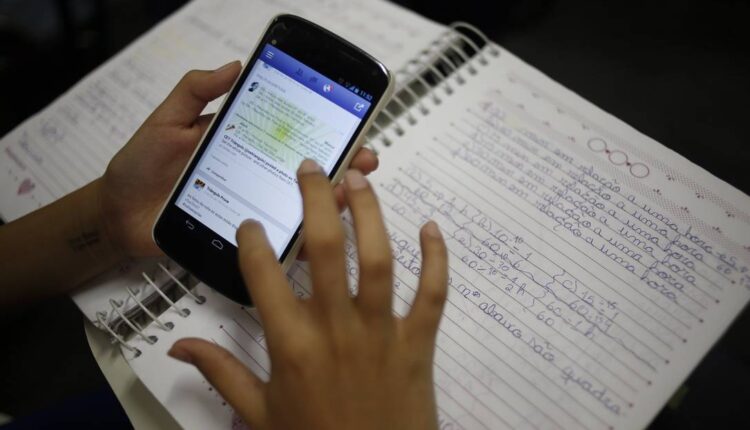 Aluno a estudar pelo celular. Imagem: Paula Giolito / Agência O Globo