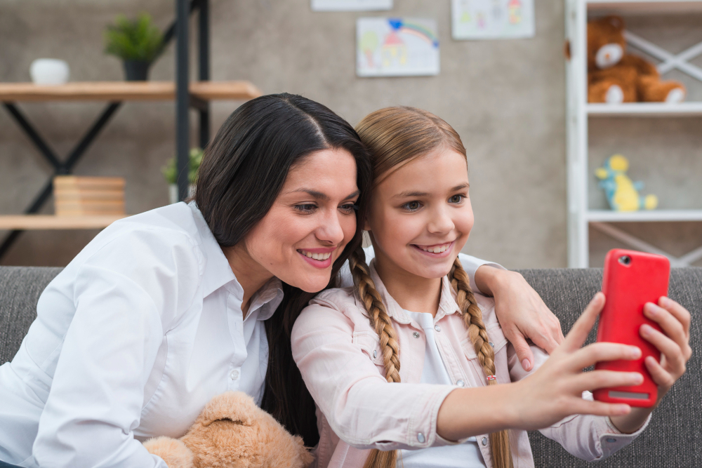 Mãe e filha fazendo selfie no celular.