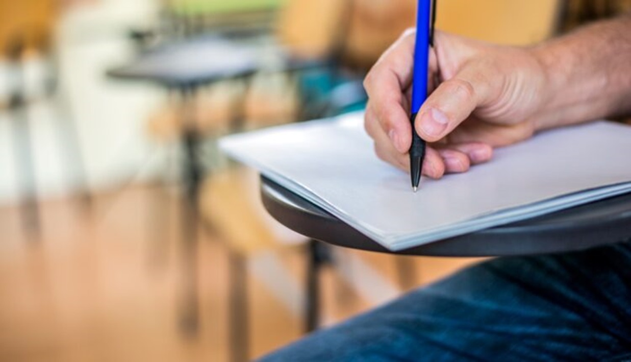 Candidato com canela na mão estudando para o concurso da Câmara Municipal de Santana de Parnaíba