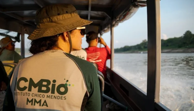 Profissional do ICMBio em atividade de campo em travessia de rio