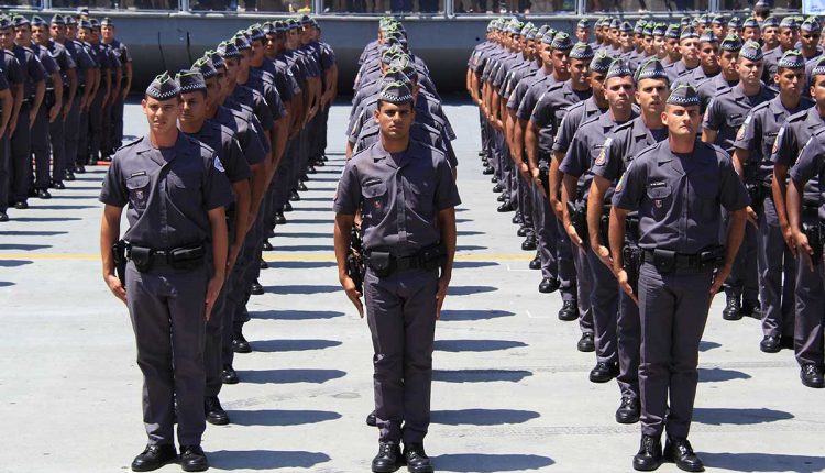 Formação de policiais militares fardados durante uma cerimônia oficial, alinhados em fileiras simétricas, demonstrando disciplina e organização