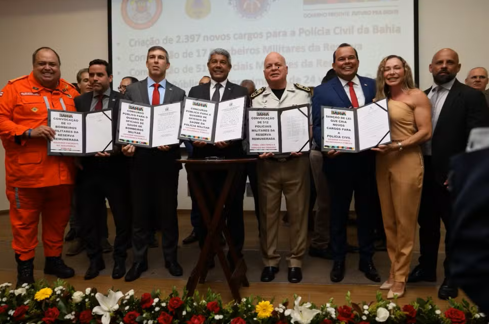 Autoridades do governo da Bahia e representantes das forças de segurança exibem documentos oficiais sobre a criação de novos cargos para a Polícia Civil e autorização de concursos para Polícia Militar e Bombeiros