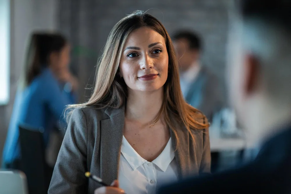 Mulher com expressão confiante em ambiente de trabalho, simbolizando uma mentalidade de crescimento