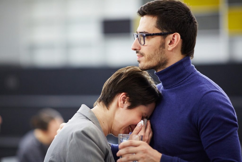 Homem confortando mulher em momento de dificuldade emocional