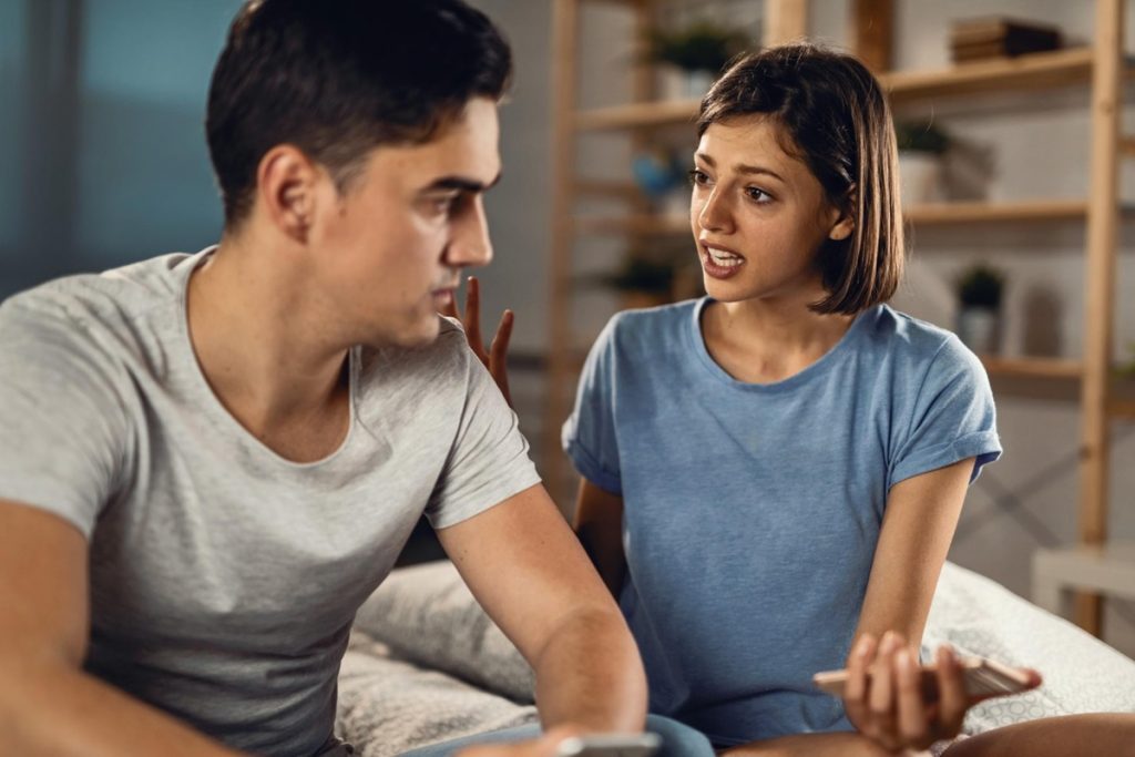 Mulher conversando seriamente com um homem, representando uma situação de ingratidão.