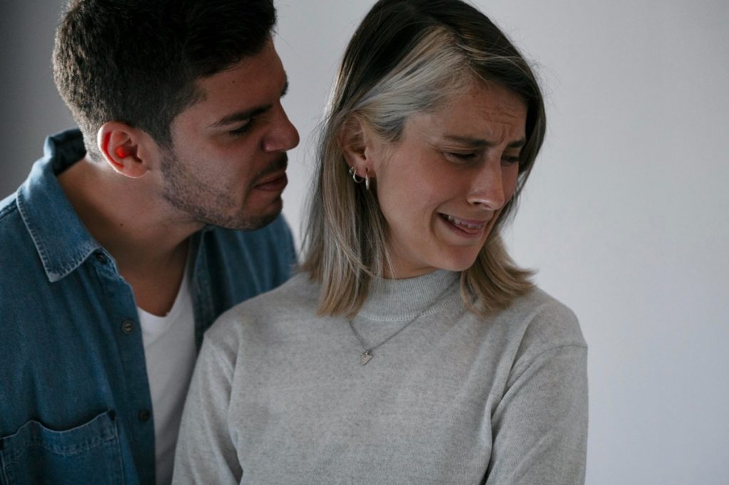 Casal em situação de ciúmes, com um deles expressando desconforto emocional.