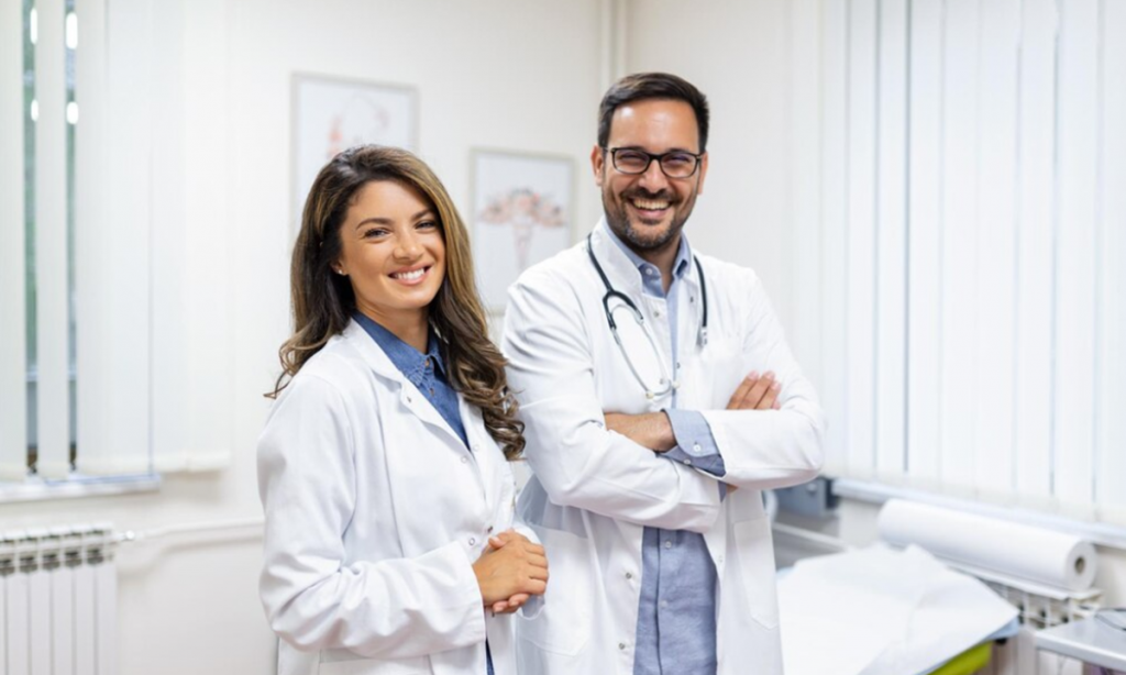 Profissionais de saúde sorrindo em um consultório médico, destacando a área com alta empregabilidade.