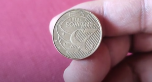 Moeda de 25 centavos com erro de reverso invertido, destacando o valor e design do ano 2014.