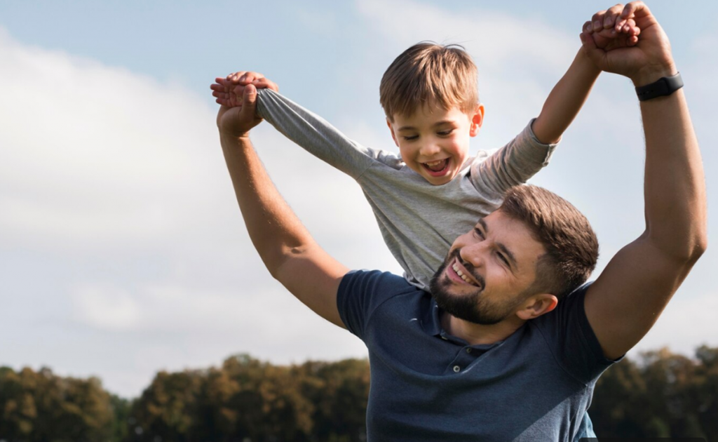 Pai e filho brincando ao ar livre com sorrisos no rosto