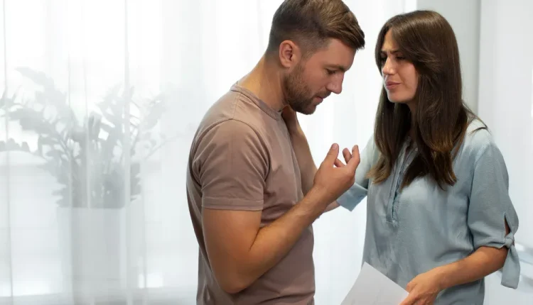 Casal discutindo enquanto segura um documento, indicando uma possível separação.