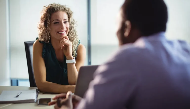 Mulher sorridente em conversa, representando expressões faciais e linguagem corporal analisadas pela psicologia.