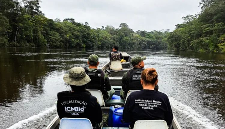 Equipe do ICMBio e Polícia Militar em fiscalização ambiental na Amazônia, navegando por um rio cercado por floresta densa.