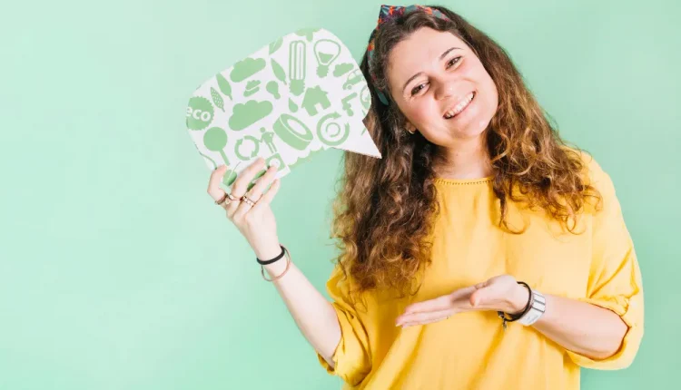 Mulher sorrindo e segurando uma plaquinha, simbolizando a inteligência emocional e a comunicação.