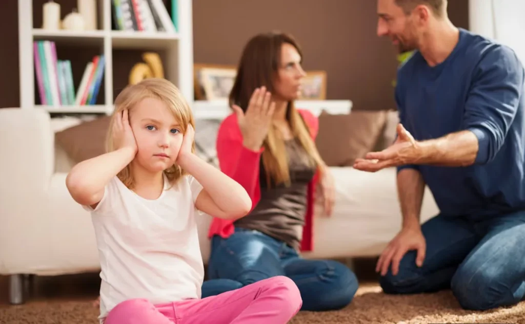 Criança tapando os ouvidos enquanto os pais discutem ao fundo, ilustrando os efeitos da negligência da saúde emocional.