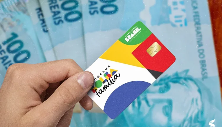 essoa segurando o cartão do Programa Bolsa Família com notas de R$100 ao fundo