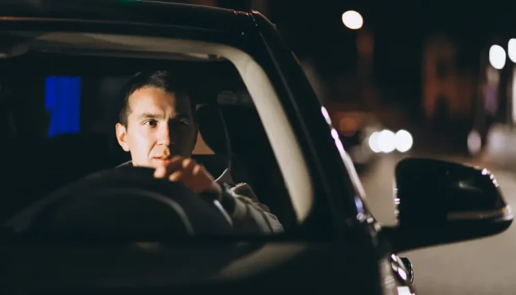 Motorista atento ao volante durante a noite, refletindo sobre sua condução