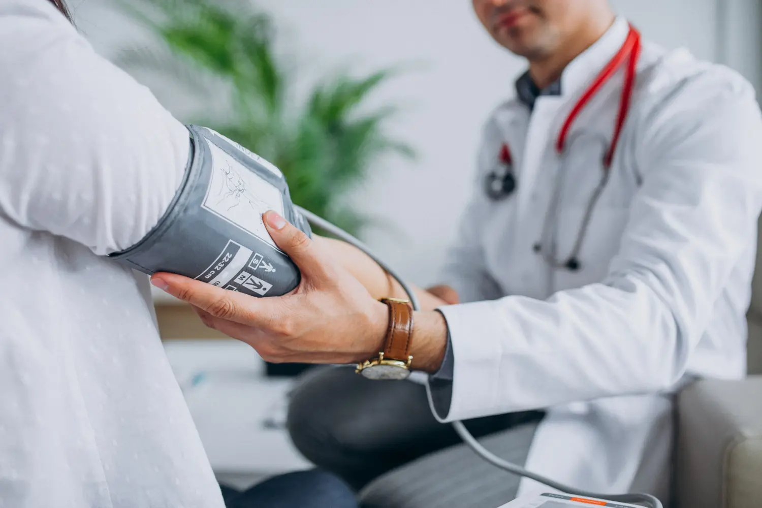 Médico realizando medição de pressão arterial em paciente, ilustrando a profissão de saúde em Portugal.