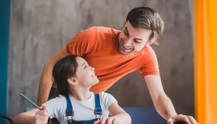 Pai e filha sorrindo enquanto compartilham um momento de aprendizado, simbolizando a importância da educação e do vínculo familiar.