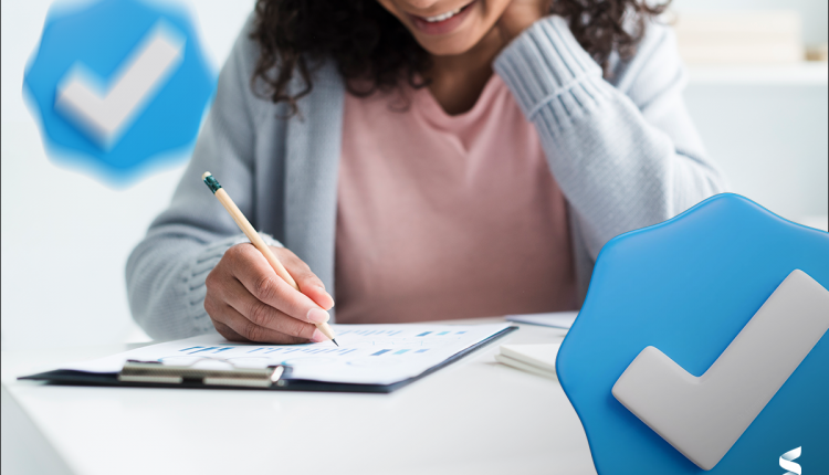 Mulher preenchendo um formulário com um sorriso, simbolizando inscrição em concurso público.