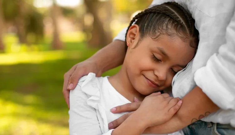 Imagem de uma mãe adotiva abraçando sua filha, simbolizando o vínculo afetivo e a questão do direito ao salário-maternidade no INSS para mães adotivas.