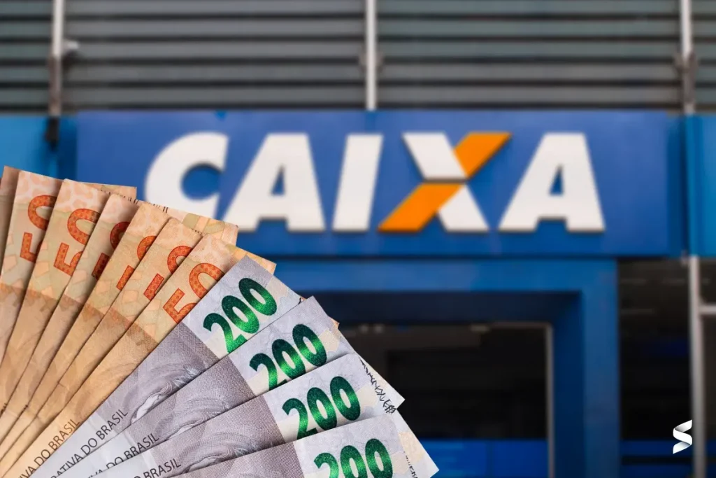 Notas de 50 e 200 reais em frente a uma agência da Caixa Econômica Federal