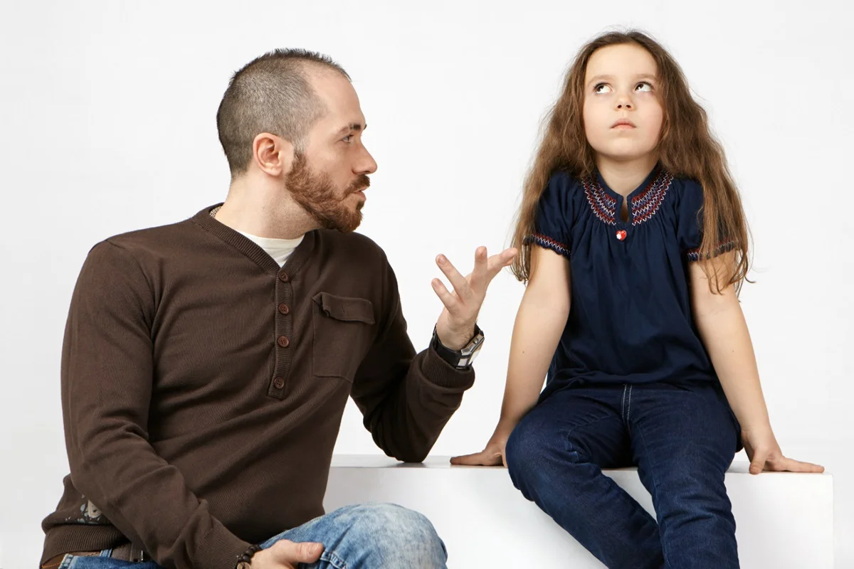 Pai estabelecendo limites para a filha, ajudando no desenvolvimento de habilidades sociais