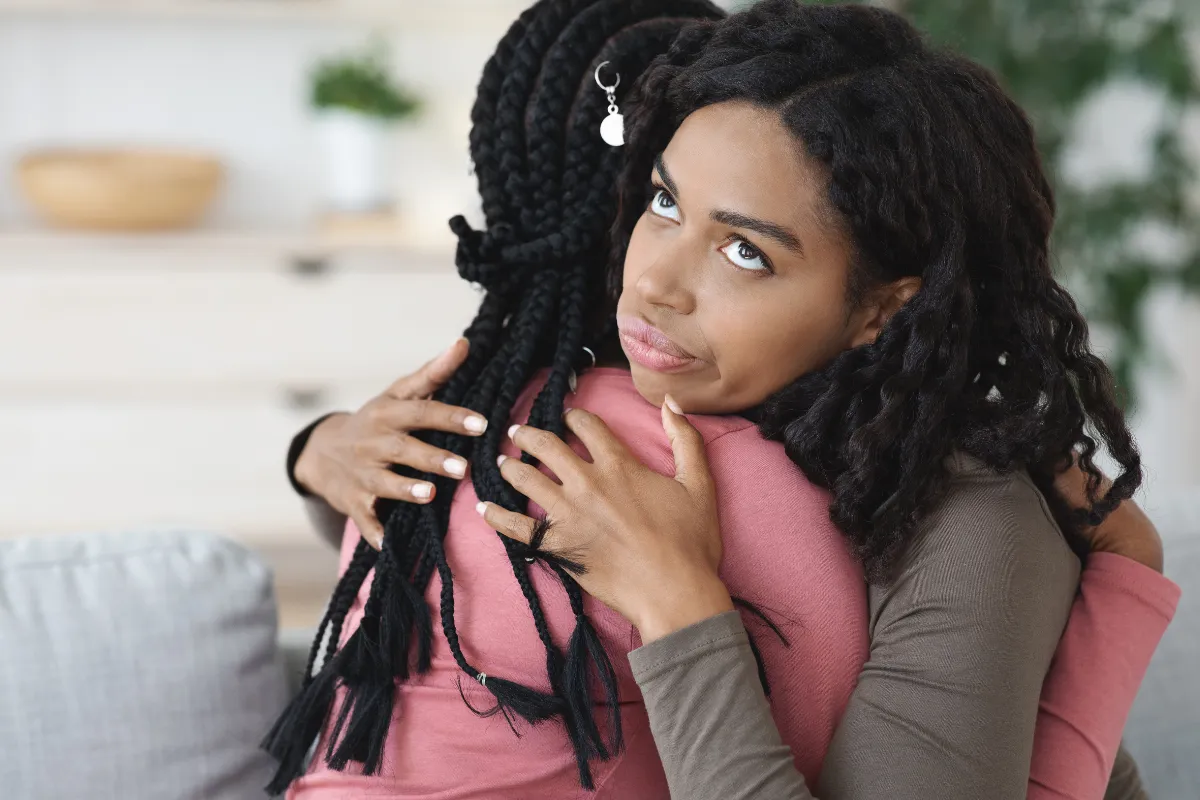 Mulher com expressão desconfortável durante um abraço, indicando uma sensação de falsidade.