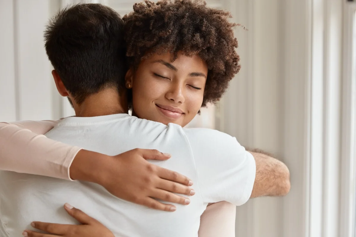 Casal se abraçando, simbolizando a liberação de oxitocina, o hormônio do afeto.