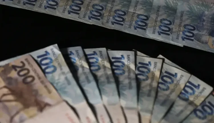 Cédulas de R$ 100 e R$ 200, representando o pagamento do PIS/Pasep