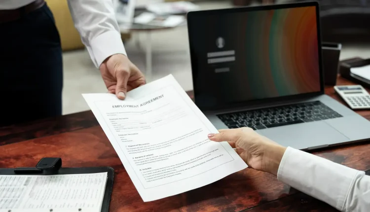 Pessoa entregando contrato de trabalho a outra pessoa, simbolizando uma contratação rápida.